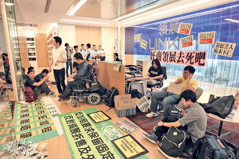 民主黨、民協、社民連等泛民政黨20多名成員,昨早到位於觀塘的領展總部示威及靜坐,並將標語貼在牆上抗議。(李紹昌攝) 民主黨、民協、社民連等泛民政黨20多名成員,昨早到位於觀塘的領展總部示威及靜坐,並將標語貼在牆上抗議。(李紹昌攝)