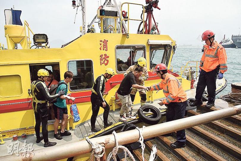 意外中受傷的駁艇乘客,由消防船載返碼頭,再轉由救護車送院治理。(鍾炳然攝) 意外中受傷的駁艇乘客,由消防船載返碼頭,再轉由救護車送院治理。(鍾炳然攝)