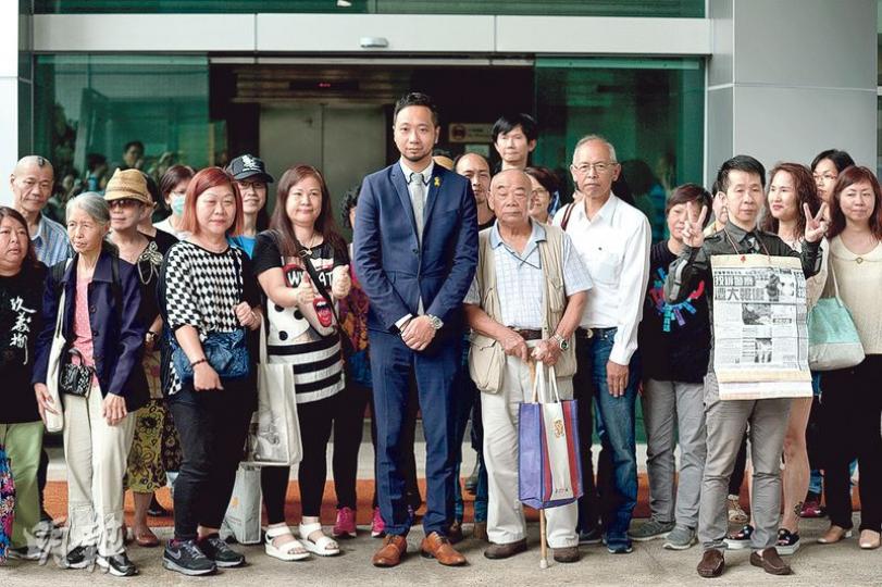 被告曾健超（圖中穿西裝者）昨獲大批支持者現身九龍城裁判法院支持，不少人在庭外與他合照握手。（鄧宗弘攝）