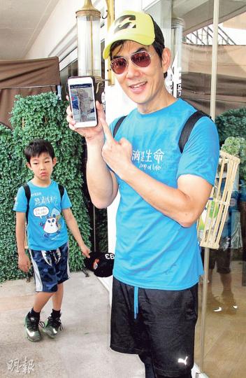任賢齊用手機展示明年達喀爾拉力賽的路線,8歲兒子Cody在後面聽爸爸受訪,算是遠距離「合照」。(攝影:鍾一虹) 任賢齊用手機展示明年達喀爾拉力賽的路線,8歲兒子Cody在後面聽爸爸受訪,算是遠距離「合照」。(攝影:鍾一虹)