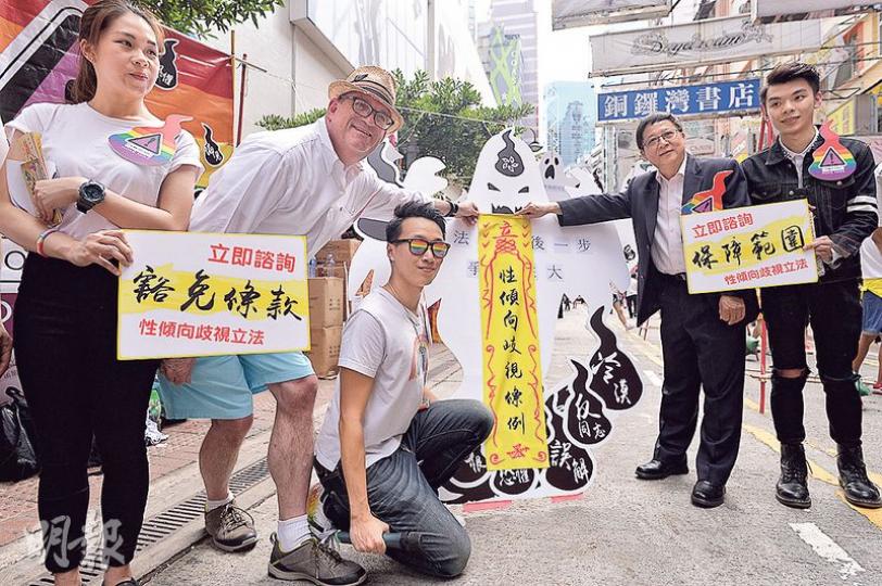 新任平機會主席陳章明(右二)昨出席任內首個同志平權活動「國際不再恐同日」街頭活動,加拿大駐香港總領事柏伊恩(左二)現身支持。各人與性小眾團體將寫有「性傾向歧視條例」的黃符張貼在紙板上,寓意消除紙牌上的「冷漠」、「誤解」等。(馮凱鍵攝) 新任平機會主席陳章明(右二)昨出席任內首個同志平權活動「國際不再恐同日」街頭活動,加拿大駐香港總領事柏伊恩(左二)現身支持。各人與性小眾團體將寫有「性傾向歧視條例」的黃符張貼在紙板上,寓意消除紙牌上的「冷漠」、「誤解」等。(馮凱鍵攝)
