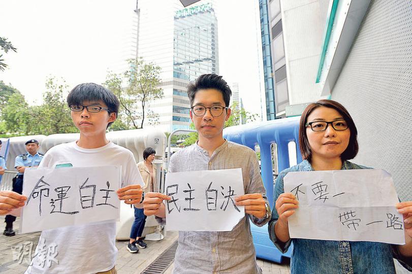 香港眾志秘書長黃之鋒(左)、主席羅冠聰(中)及「小麗民主教室」發起人劉小麗(右)等於張德江車隊抵達酒店前持「命運自主」、「民主自決」等標語並欲突圍,被警方阻止及收起標語。(楊柏賢攝)新民主同盟昨在添馬公園豎立100個「十字」墓碑紙牌,向2003年因感染SARS逝世的299名死難者默哀悼念。(郭慶輝攝)有社聯職員在灣仔溫莎公爵大廈社聯總部的寫字樓窗戶貼上「真普選」字眼及黃傘標語,途人在灣仔軒尼詩道抬頭可見。(林俊源攝) 香港眾志秘書長黃之鋒(左)、主席羅冠聰(中)及「小麗民主教室」發起人劉小麗(右)等於張德江車隊抵達酒店前持「命運自主」、「民主自決」等標語並欲突圍,被警方阻止及收起標語。(楊柏賢攝)新民主同盟昨在添馬公園豎立100個「十字」墓碑紙牌,向2003年因感染SARS逝世的299名死難者默哀悼念。(郭慶輝攝)有社聯職員在灣仔溫莎公爵大廈社聯總部的寫字樓窗戶貼上「真普選」字眼及黃傘標語,途人在灣仔軒尼詩道抬頭可見。(林俊源攝)