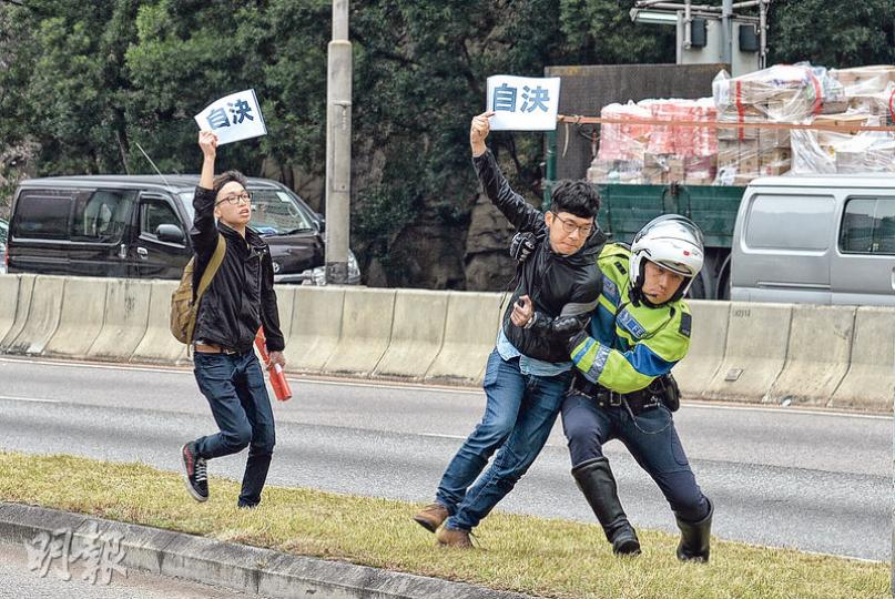 全國人大委員長張德江昨日最後一天訪港,先在灣仔與各界代表會晤,說「自決」「港獨」成不了事。然後在反恐級別的保安下乘車經東區海底隧道往訪將軍澳老人院。5名香港眾志成員昨晨10時於東隧九龍出口,意圖衝出馬路攔截張德江車隊,該黨主席羅冠聰(右二)等手持「自決」標語,有交通警員趕到現場阻截各人。(楊柏賢攝) 全國人大委員長張德江昨日最後一天訪港,先在灣仔與各界代表會晤,說「自決」「港獨」成不了事。然後在反恐級別的保安下乘車經東區海底隧道往訪將軍澳老人院。5名香港眾志成員昨晨10時於東隧九龍出口,意圖衝出馬路攔截張德江車隊,該黨主席羅冠聰(右二)等手持「自決」標語,有交通警員趕到現場阻截各人。(楊柏賢攝)
