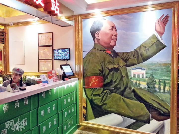 重慶「老基地」火鍋店標明「紅色文化主題」,店內充滿文革元素。收銀台的背景是文革期間毛澤東接見紅衛兵的畫像。(明報記者攝) 重慶「老基地」火鍋店標明「紅色文化主題」,店內充滿文革元素。收銀台的背景是文革期間毛澤東接見紅衛兵的畫像。(明報記者攝)
