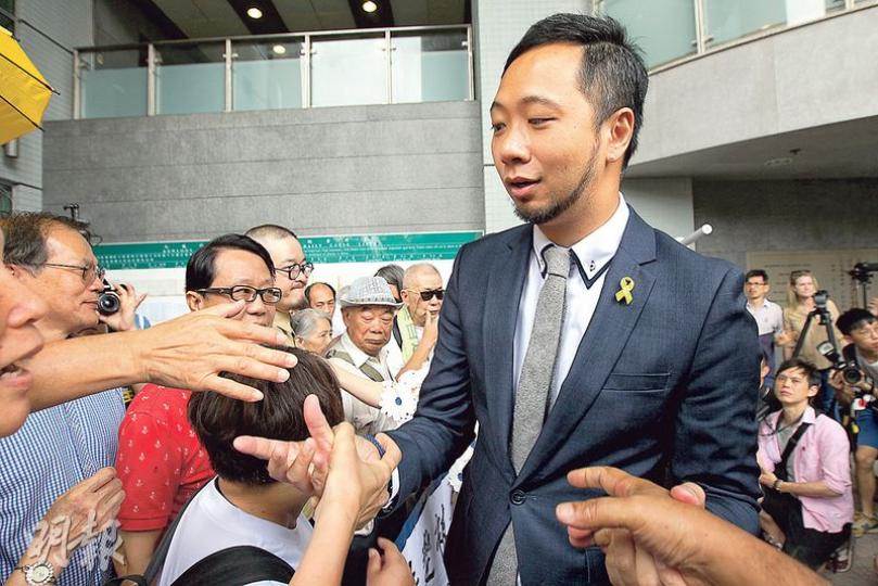 曾健超(穿西裝者)昨到九龍城裁判法院聽取裁決,超過70名支持者到庭支持,他在庭外與他們握手。(李紹昌攝) 曾健超(穿西裝者)昨到九龍城裁判法院聽取裁決,超過70名支持者到庭支持,他在庭外與他們握手。(李紹昌攝)