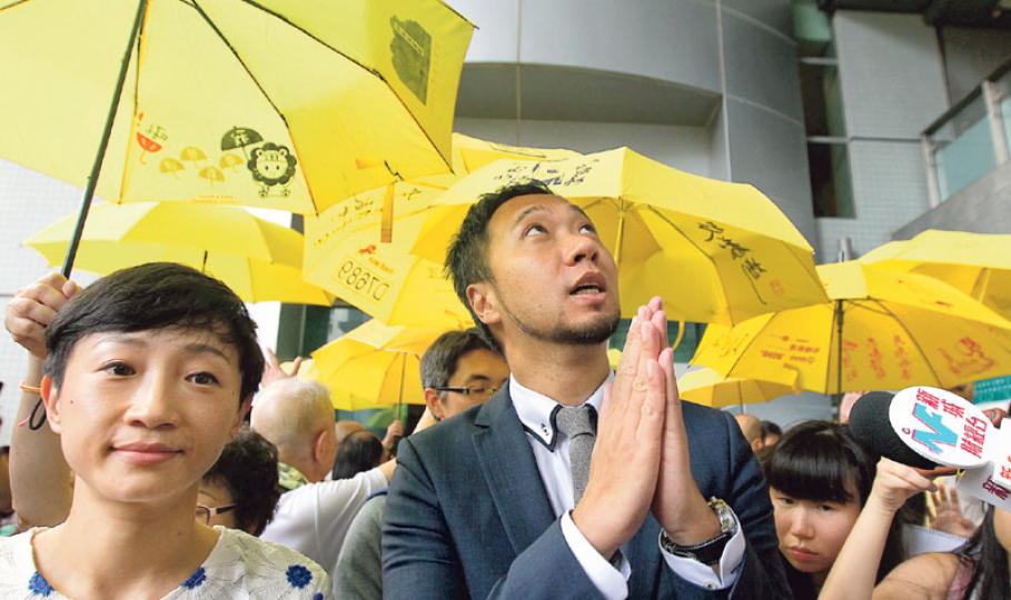 「七警案」主角、公民黨成員曾健超（穿西裝者）被指在佔領運動期間，向警察淋潑有味液體及拒捕，經審訊後昨被裁定1項襲警及2項拒捕罪成，獲准保釋候判。裁決後他於黨友陳淑莊（左）陪同下在法院外見記者，表示對裁決失望，將與法律團隊研究會否上訴。（李紹昌攝）