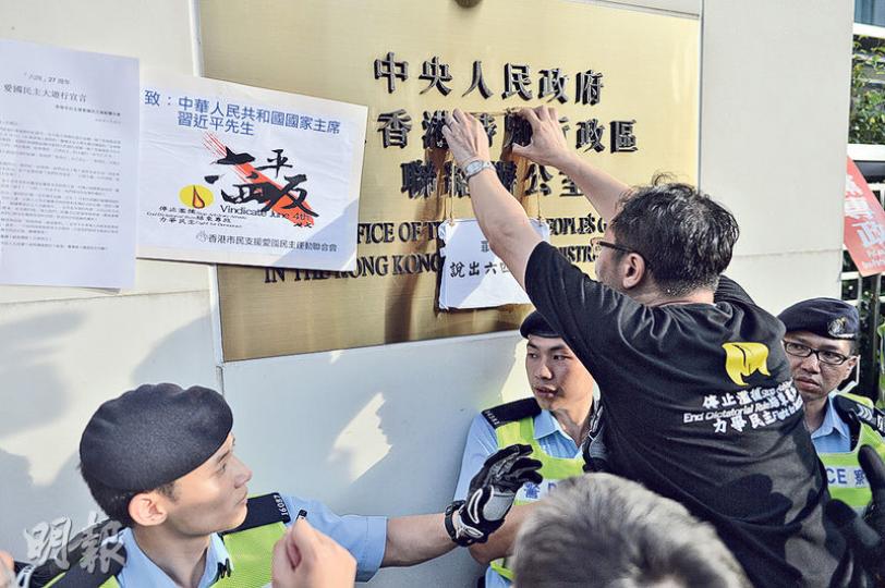 支聯會副主席蔡耀昌(背向鏡頭者)昨遊行抵達中聯辦後,將請願標語掛在中聯辦外門牌,另有遊行人士將請願信貼在門牌旁,有人向中聯辦撒溪錢,警方曾數次警告,最終未採取任何行動。(蘇智鑫攝) 支聯會副主席蔡耀昌(背向鏡頭者)昨遊行抵達中聯辦後,將請願標語掛在中聯辦外門牌,另有遊行人士將請願信貼在門牌旁,有人向中聯辦撒溪錢,警方曾數次警告,最終未採取任何行動。(蘇智鑫攝)