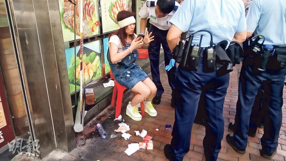 案發後,遇劫女事主在現場附近店舖外接受包紮及向警員講述案發經過。(林智傑攝) 案發後,遇劫女事主在現場附近店舖外接受包紮及向警員講述案發經過。(林智傑攝)