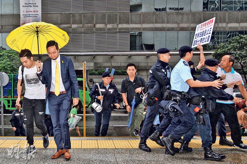 曾健超(左二)昨抵達法院時,撐警團體高叫「監躉超、監躉超」,曾健超聞言面帶微笑。一名示威者(右一)高舉紙牌衝出示威區走向曾健超,被警員阻止。(林俊源攝)7名被告昨乘私家車,繼續繫同款領帶到庭應訊。圖為有組織罪案及三合會調查科總督察黃祖成(右起)、觀塘反黑組高級督察劉卓毅、觀塘反黑組偵緝警員黃偉豪及觀塘反黑組偵緝警長白榮斌。(林俊源攝) 曾健超(左二)昨抵達法院時,撐警團體高叫「監躉超、監躉超」,曾健超聞言面帶微笑。一名示威者(右一)高舉紙牌衝出示威區走向曾健超,被警員阻止。(林俊源攝)7名被告昨乘私家車,繼續繫同款領帶到庭應訊。圖為有組織罪案及三合會調查科總督察黃祖成(右起)、觀塘反黑組高級督察劉卓毅、觀塘反黑組偵緝警員黃偉豪及觀塘反黑組偵緝警長白榮斌。(林俊源攝)