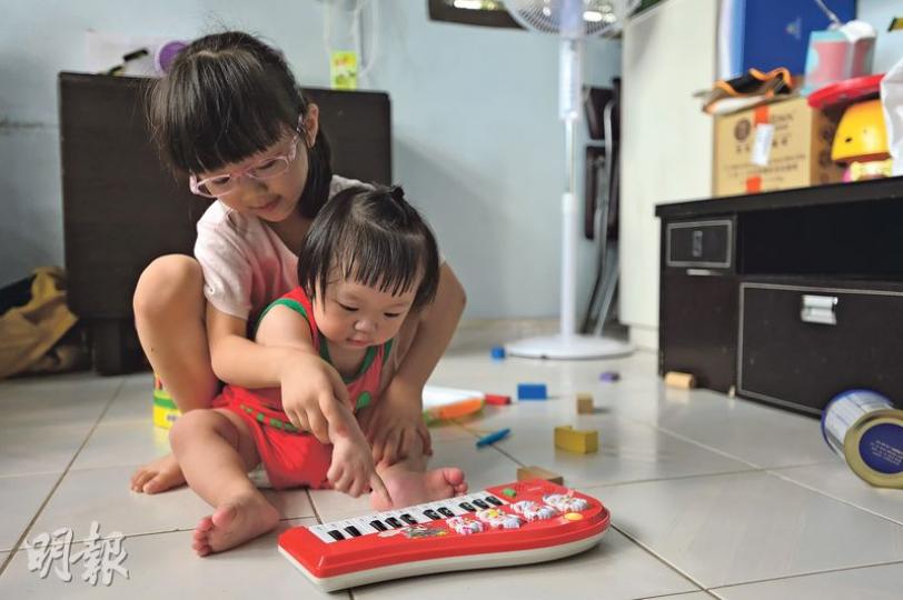 就讀K3、等待升小學的阿怡(後)和仍未入讀幼稚園的妹妹(前)均喜歡繪畫、彈琴及跳舞,不過經濟條件所限,她未能報讀興趣班,跟其他同齡兒童一起學習、一起成長,兩姊妹只能留在家,拿起舊玩具自娛。其母盼政府多提供資助,讓子女培養一種興趣,學一種技能。(鄧宗弘攝) 就讀K3、等待升小學的阿怡(後)和仍未入讀幼稚園的妹妹(前)均喜歡繪畫、彈琴及跳舞,不過經濟條件所限,她未能報讀興趣班,跟其他同齡兒童一起學習、一起成長,兩姊妹只能留在家,拿起舊玩具自娛。其母盼政府多提供資助,讓子女培養一種興趣,學一種技能。(鄧宗弘攝)