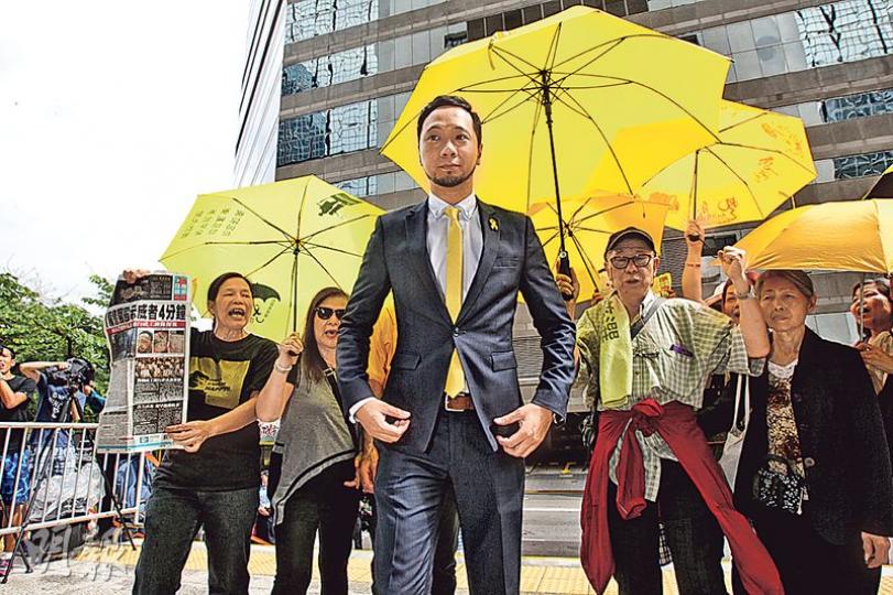 曾健超(中)昨在數名舉黃傘支持者陪同下到庭,其支持者不斷叫「加油」,一批撐警示威者則以擴音器不斷罵他「監躉超」。(李紹昌攝) 曾健超(中)昨在數名舉黃傘支持者陪同下到庭,其支持者不斷叫「加油」,一批撐警示威者則以擴音器不斷罵他「監躉超」。(李紹昌攝)