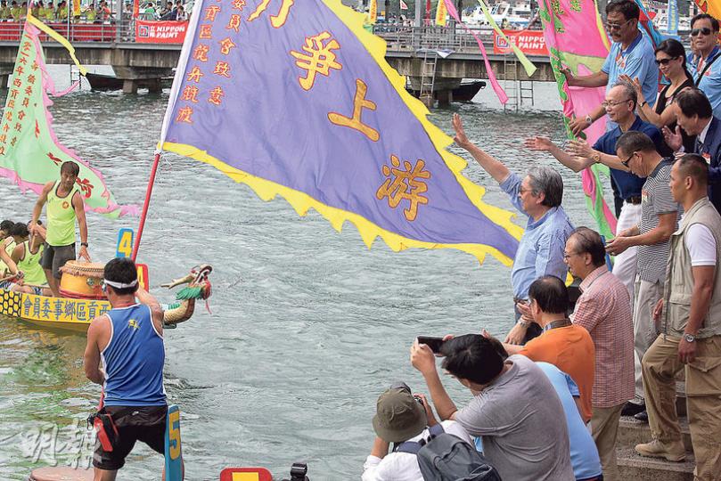 盛傳係參選下任特首選舉熱門人選嘅財政司長曾俊華(圖右揮手者)噚日出席西貢龍舟賽,喺「力爭上游」旗幟旁向健兒揮手。佢噚日都喺facebook貼咗一幅構圖相近嘅相片,有網民問財爺係咪講緊「曾」上游。(林俊源攝)社民連成員噚日去西貢龍舟賽,向以署理特首身分出席活動嘅曾俊華示威,帶埋道具糉,諷刺特首梁振英同涉嫌喺佔領運動毆傷市民嘅警官。(林俊源攝) 盛傳係參選下任特首選舉熱門人選嘅財政司長曾俊華(圖右揮手者)噚日出席西貢龍舟賽,喺「力爭上游」旗幟旁向健兒揮手。佢噚日都喺facebook貼咗一幅構圖相近嘅相片,有網民問財爺係咪講緊「曾」上游。(林俊源攝)社民連成員噚日去西貢龍舟賽,向以署理特首身分出席活動嘅曾俊華示威,帶埋道具糉,諷刺特首梁振英同涉嫌喺佔領運動毆傷市民嘅警官。(林俊源攝)