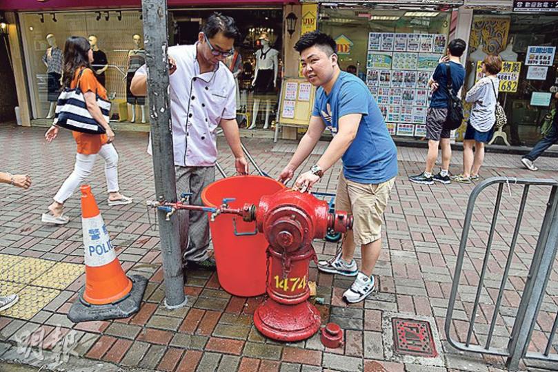 食肆職員到城巿花園對出街上消防栓取水,笑稱「好似返去70年代」。(林智傑攝) 食肆職員到城巿花園對出街上消防栓取水,笑稱「好似返去70年代」。(林智傑攝)