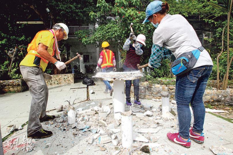 地政總署外判工人昨到東丫背村移除被霸佔官地上的雜物,其中勞工處前助理處長麥世耀違建的花園,多個花盆及擺設被移走,石枱亦被打破。(林俊源攝)地政總署人員昨到東丫背村清理官地上的雜物後,在多處以電鑽鑽孔,設置多個「政府官地」告示牌,要求有關人等須在明天前停止佔用政府土地。(林俊源攝)地政總署人員清除霸佔官地雜物期間,一隻巨型陸龜到處爬行,無人看管。及後愛護動物協會派員準備捉走該陸龜時,曾文進大宅內一名傭工將龜抱回屋內。(林俊源攝) 地政總署外判工人昨到東丫背村移除被霸佔官地上的雜物,其中勞工處前助理處長麥世耀違建的花園,多個花盆及擺設被移走,石枱亦被打破。(林俊源攝)地政總署人員昨到東丫背村清理官地上的雜物後,在多處以電鑽鑽孔,設置多個「政府官地」告示牌,要求有關人等須在明天前停止佔用政府土地。(林俊源攝)地政總署人員清除霸佔官地雜物期間,一隻巨型陸龜到處爬行,無人看管。及後愛護動物協會派員準備捉走該陸龜時,曾文進大宅內一名傭工將龜抱回屋內。(林俊源攝)
