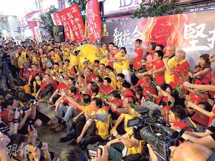 人民力量同社民連噚日喺銅鑼灣東角道宣布成立「人社選舉聯盟」，近50個支持者到場，眾人手持代表社民連嘅紅色玫瑰花，同戴上象徵人民力量嘅黃色手帶，希望「團結就是力量」，合力喺立法會選舉爭取議席。（梁智康攝）