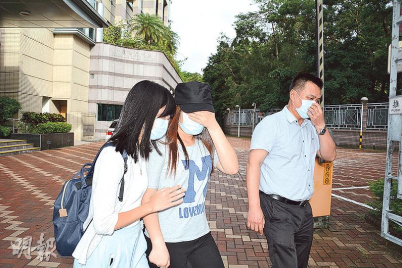 被告梁思敏（中）昨午在親友陪同下離開粉嶺裁判法院。（許芳文攝）