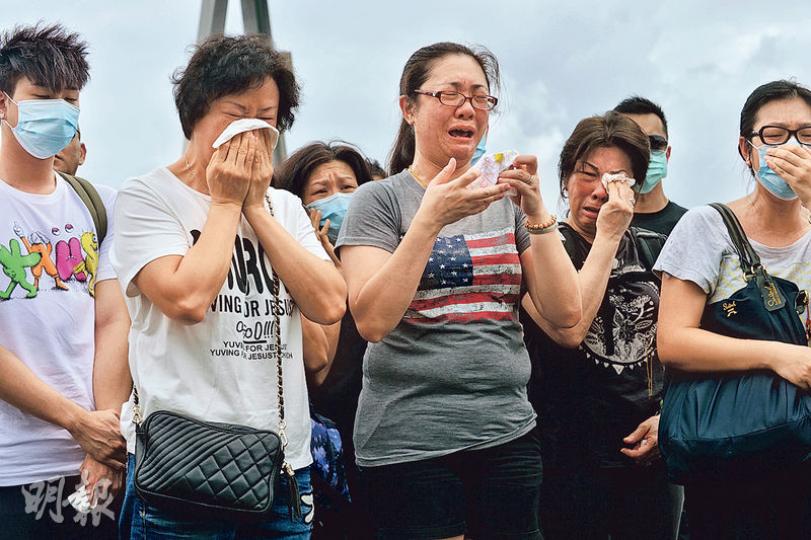 前日青葵公路車禍中，兩名死者的家人及親友昨午獲安排到車禍現場拜祭，其中陳木完的妻子（前左三）再次難掩哀傷，放聲嚎哭。（蘇智鑫攝）