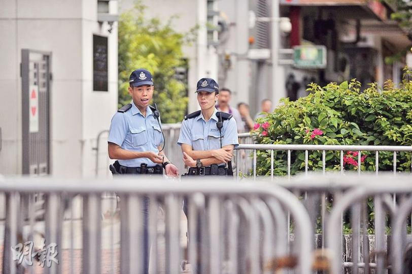七一前夕，中聯辦門外警力與平日相若，門前有兩名警員把守。（馮凱鍵攝）警方昨晚於金鐘港鐵站通往政府總部及中信大廈一帶的有蓋天橋繫上一排鐵欄，作臨時封閉天橋之用。（鍾林枝攝）