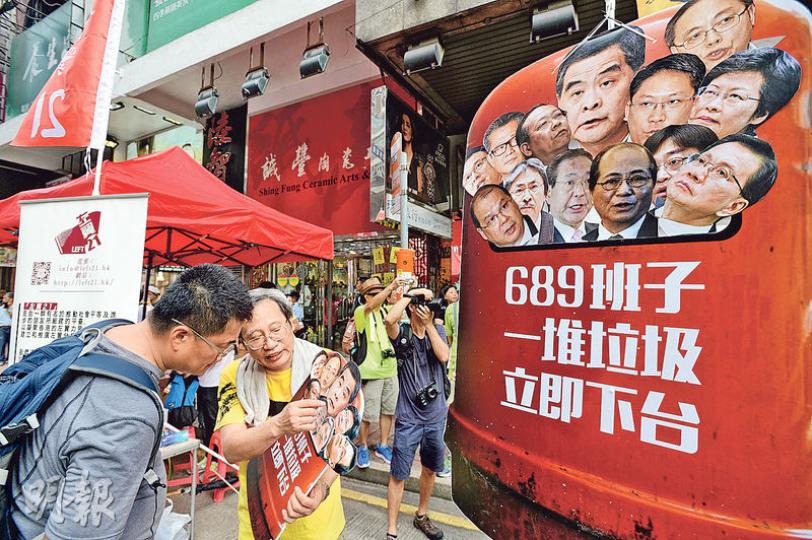 今年七一遊行以「決戰689」為主題,沿途街站亦以踢走梁班子作回應,人民力量街站的示威道具,將梁振英及一眾司局長、行政會議成員李國章等大頭照放入垃圾桶,要求「689班子一堆垃圾立即下台」。(楊柏賢攝)親建制團體「保衛香港運動」昨午亦在銅鑼灣遊行,高呼「拉布流會、正一垃圾」等口號,批評泛民阻礙政府施政。他們用腳踢貼上泛民議員照片的黃色氣球,寓意在9月立法會選舉將泛民踢出議會。(林俊源攝) 今年七一遊行以「決戰689」為主題,沿途街站亦以踢走梁班子作回應,人民力量街站的示威道具,將梁振英及一眾司局長、行政會議成員李國章等大頭照放入垃圾桶,要求「689班子一堆垃圾立即下台」。(楊柏賢攝)親建制團體「保衛香港運動」昨午亦在銅鑼灣遊行,高呼「拉布流會、正一垃圾」等口號,批評泛民阻礙政府施政。他們用腳踢貼上泛民議員照片的黃色氣球,寓意在9月立法會選舉將泛民踢出議會。(林俊源攝)