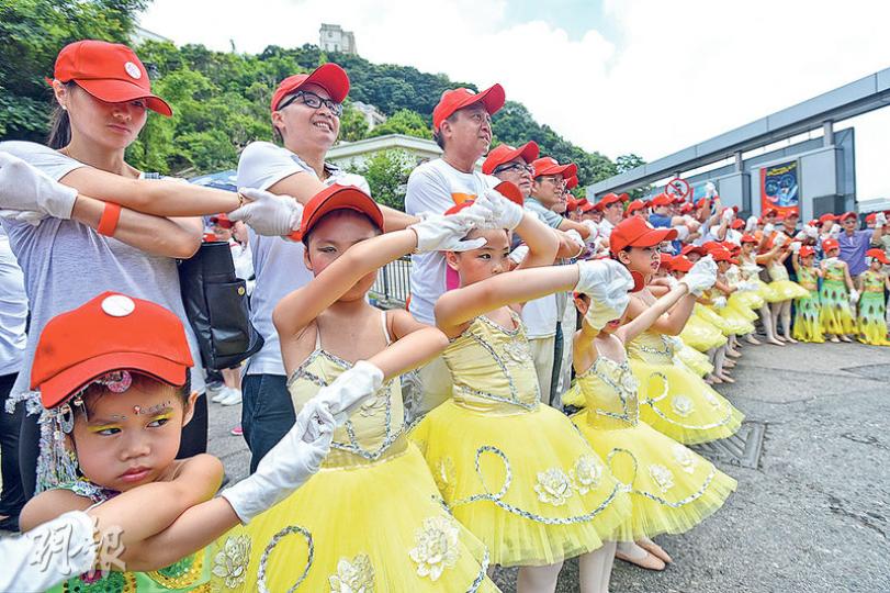 「幫港出聲」同「保普選保和平大聯盟」發起手牽手圍繞太平山頂行動，聲稱有5000至6000人參與，圖中著住跳舞衫嘅小朋友緊握左右隔籬嘅同伴，以防「斷纜」。（楊柏賢攝）