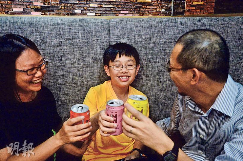 牧師劉英峰(右)與太太(左)昨與次子(中)飲汽水慶祝他完成小學,夫婦倆不要求兒子取得好成績或入名校,而是更注重其品格與抗逆能力等。(楊柏賢攝) 牧師劉英峰(右)與太太(左)昨與次子(中)飲汽水慶祝他完成小學,夫婦倆不要求兒子取得好成績或入名校,而是更注重其品格與抗逆能力等。(楊柏賢攝)
