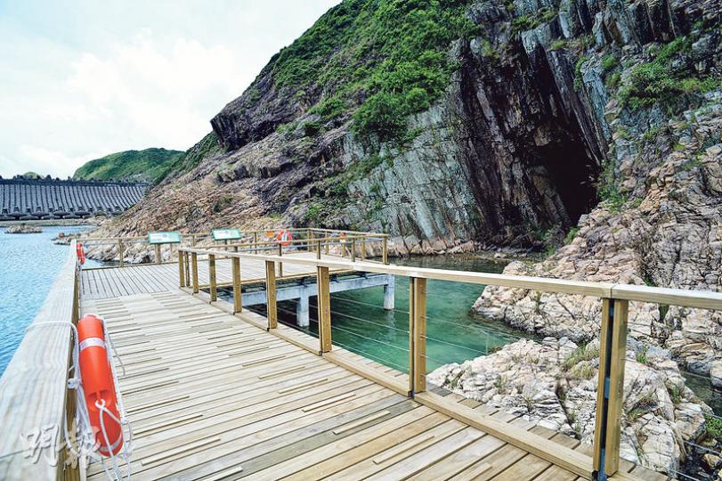 萬宜水庫東壩的木橋步道長50米,可助遊人近距離欣賞海蝕洞(圖右)。漁護署指所用的木板均十分耐用,至少可保持50年不變。(蘇智鑫攝)萬宜水庫東壩新建的資訊站,每逢周末和假日都有地質導賞員駐守,署方更找來藝術家粉飾小屋,以東壩的特色如六角形岩柱和海蝕洞作主要設計元素。(蘇智鑫攝) 萬宜水庫東壩的木橋步道長50米,可助遊人近距離欣賞海蝕洞(圖右)。漁護署指所用的木板均十分耐用,至少可保持50年不變。(蘇智鑫攝)萬宜水庫東壩新建的資訊站,每逢周末和假日都有地質導賞員駐守,署方更找來藝術家粉飾小屋,以東壩的特色如六角形岩柱和海蝕洞作主要設計元素。(蘇智鑫攝)