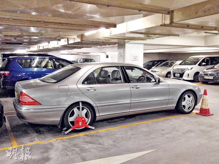 因車主不滿被鎖車,一度堵塞停車場入口的平治房車,昨午再次因被指欠交費用而被鎖車。(伍浦鋒攝) 因車主不滿被鎖車,一度堵塞停車場入口的平治房車,昨午再次因被指欠交費用而被鎖車。(伍浦鋒攝)