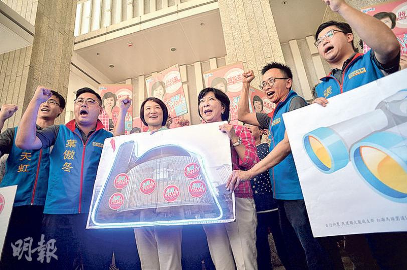 民建聯蔣麗芸（右三）團隊昨日報名參選九龍西，參選超區的黨主席李慧琼（左三）到場支持。競選團隊將寫有口號的貼紙貼在有立法會外貌的紙牌上並亮燈，寓意要點亮議會。（蘇智鑫攝）劉小麗（中）昨日持500個提名報名參選九龍西，參選新西的社運人士朱凱迪（左）、參選港島的香港眾志羅冠聰（右）等到場支持。（馮凱鍵攝）