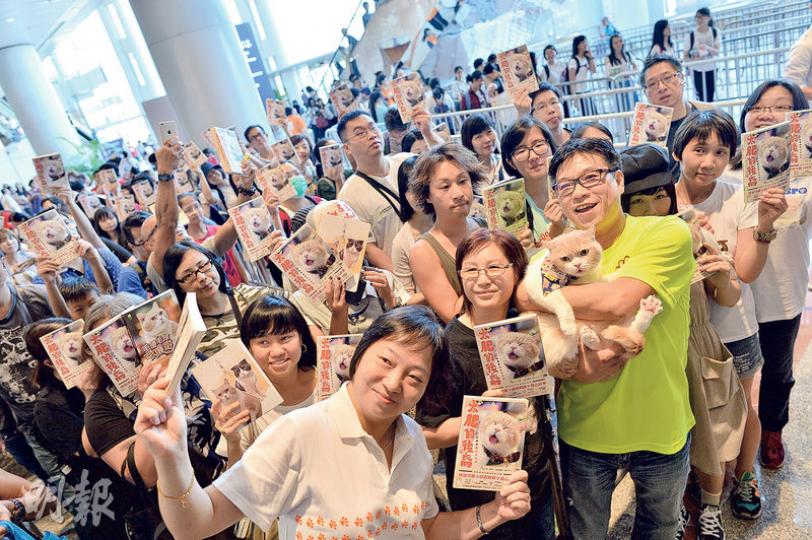 明星貓「忌廉哥」闊別尖東兩個月,昨出席書展新書簽名會與粉絲見面。支持者高舉忌廉哥的新書《太肥的後裔》,與牠及主人高先生合照,顯得十分興奮。(蘇智鑫攝) 明星貓「忌廉哥」闊別尖東兩個月,昨出席書展新書簽名會與粉絲見面。支持者高舉忌廉哥的新書《太肥的後裔》,與牠及主人高先生合照,顯得十分興奮。(蘇智鑫攝)