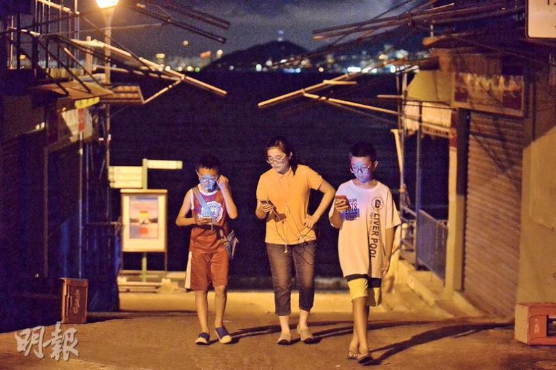 夜幕低垂後,長洲有不少青少年和成年人在大街小巷結伴徘徊,低頭望着手機追蹤小精靈。(馮凱鍵攝) 夜幕低垂後,長洲有不少青少年和成年人在大街小巷結伴徘徊,低頭望着手機追蹤小精靈。(馮凱鍵攝)
