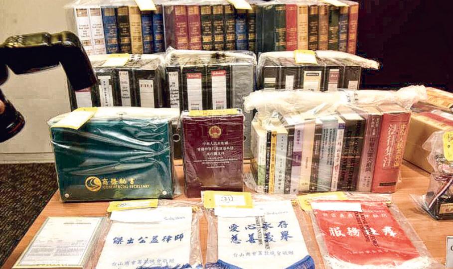 警方行動中檢獲的證物,包括假法律文件、法律書籍等,另外亦有多面錦旗及多個獎杯,其中一面錦旗寫有「傑出公益律師 台山商會籌款晚會敬贈」等字眼。(鍾炳然攝) 警方行動中檢獲的證物,包括假法律文件、法律書籍等,另外亦有多面錦旗及多個獎杯,其中一面錦旗寫有「傑出公益律師 台山商會籌款晚會敬贈」等字眼。(鍾炳然攝)