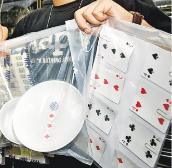 警方在行動中檢獲紙製的越南骰寶賭具(圖左),有人剪下啤牌圖案,代替骰仔,放在碗內搖晃賭博。(蔡方山攝) 警方在行動中檢獲紙製的越南骰寶賭具(圖左),有人剪下啤牌圖案,代替骰仔,放在碗內搖晃賭博。(蔡方山攝)