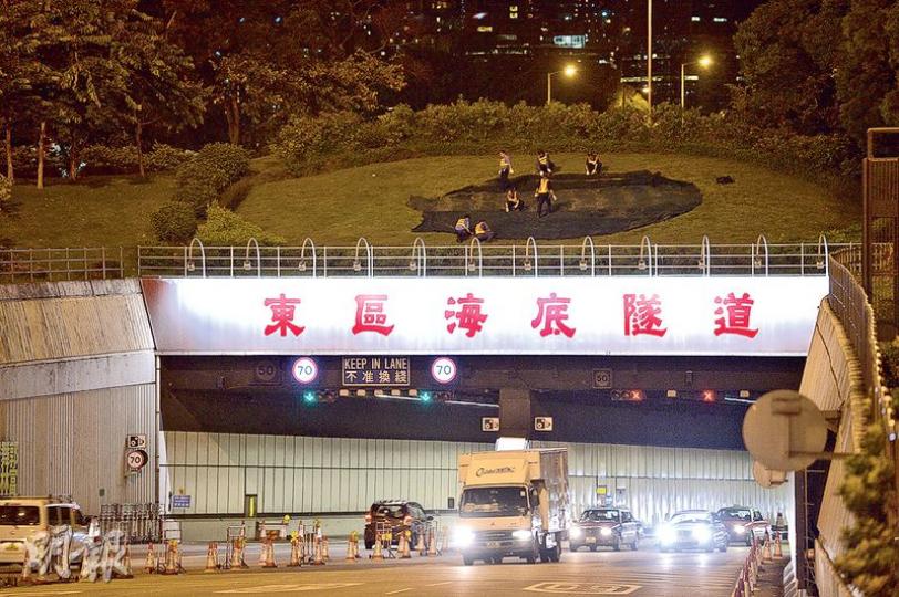 東區海底隧道30年的專營權昨晚結束,政府今日凌晨已收回隧道,凌晨交接期間隧道人手收費,工作人員覆蓋原本經營隧道的公司標誌。 (鍾林枝攝) 東區海底隧道30年的專營權昨晚結束,政府今日凌晨已收回隧道,凌晨交接期間隧道人手收費,工作人員覆蓋原本經營隧道的公司標誌。 (鍾林枝攝)