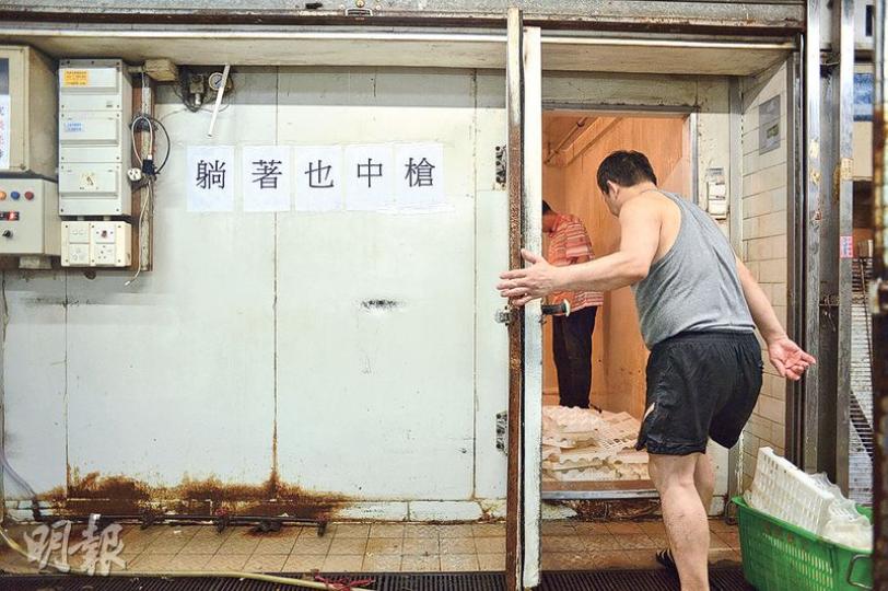 食環署銷毁永成號的懷疑問題豬後,職員隨即清洗檔口。凍櫃則貼有「躺著也中槍」字句,抗議被錯誤「點名」。(鍾林枝攝) 食環署銷毁永成號的懷疑問題豬後,職員隨即清洗檔口。凍櫃則貼有「躺著也中槍」字句,抗議被錯誤「點名」。(鍾林枝攝)