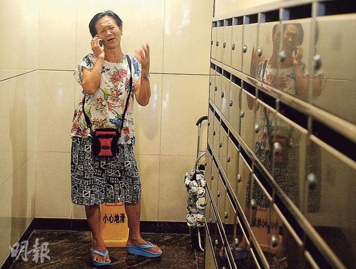 女死者的母親昨早到惠安街現場時才獲悉女兒遇害,她在電梯大堂以家鄉話通電話時,情緒激動。(衛永康攝) 女死者的母親昨早到惠安街現場時才獲悉女兒遇害,她在電梯大堂以家鄉話通電話時,情緒激動。(衛永康攝)