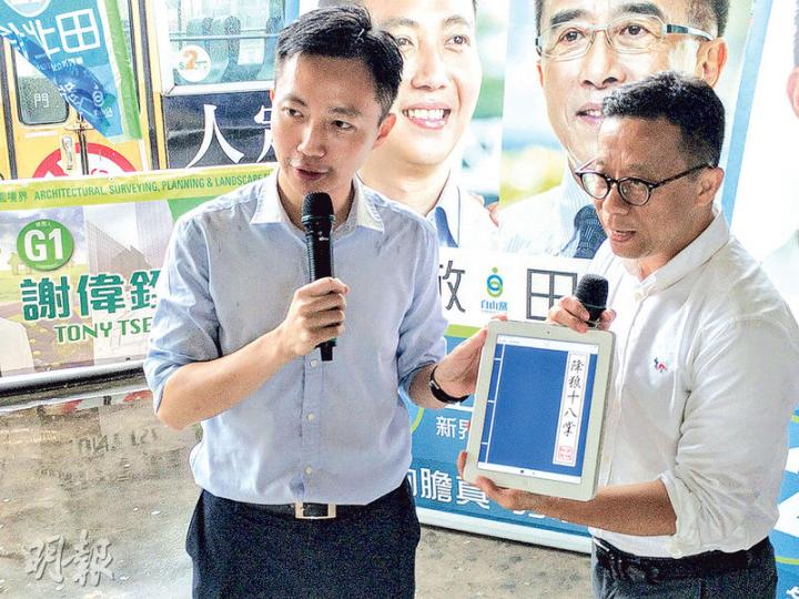 王維基(右)噚日跨區為同樣反對特首梁振英連任嘅自由黨李梓敬站台,佢以平板電腦「送」一本電子「降狼十八掌」畀李梓敬,李梓敬就以「打狗棒」回禮。(梁智康攝) 王維基(右)噚日跨區為同樣反對特首梁振英連任嘅自由黨李梓敬站台,佢以平板電腦「送」一本電子「降狼十八掌」畀李梓敬,李梓敬就以「打狗棒」回禮。(梁智康攝)