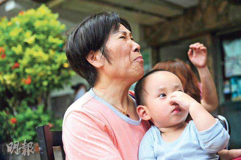 15樓單位女戶主抱着外孫(圖)偕丈夫逃生,未有關上木門,致濃煙湧入屋,被誤會單位發生火警。(賴俊傑攝)有住戶逃生時帶同愛貓到樓下安全地方。(賴俊傑攝) 15樓單位女戶主抱着外孫(圖)偕丈夫逃生,未有關上木門,致濃煙湧入屋,被誤會單位發生火警。(賴俊傑攝)有住戶逃生時帶同愛貓到樓下安全地方。(賴俊傑攝)