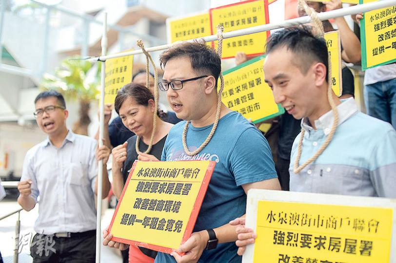 沙田水泉澳邨街市一批商戶昨到房署何文田總部示威,抗議該邨興建進度延誤,入伙進度遠遜預期,令街市人流稀疏,商戶要「蝕租、蝕貨、蝕人工」。商戶頸套麻繩,喻意被逼上絕路。(鍾林枝攝) 沙田水泉澳邨街市一批商戶昨到房署何文田總部示威,抗議該邨興建進度延誤,入伙進度遠遜預期,令街市人流稀疏,商戶要「蝕租、蝕貨、蝕人工」。商戶頸套麻繩,喻意被逼上絕路。(鍾林枝攝)