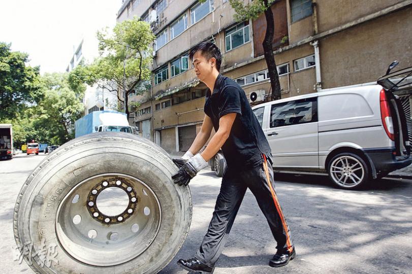 鍾浩賢烈日下推着大車胎,坦言有點吃力,但他盼為輪胎行業帶來新希望。(郭慶輝攝) 鍾浩賢烈日下推着大車胎,坦言有點吃力,但他盼為輪胎行業帶來新希望。(郭慶輝攝)