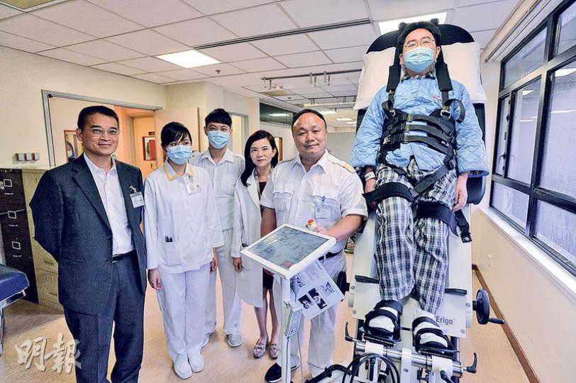 沙田醫院一級物理治療師陳暉立(右二)指出,混合性機械下肢訓練能輔助病人像「太空漫步」般走路,以加快恢復病人下肢的能力。旁為沙田醫院部門經理(物理治療)黎偉健(左一)和內科及老人科部門主管許鷗思醫生(右三)。(楊柏賢攝) 沙田醫院一級物理治療師陳暉立(右二)指出,混合性機械下肢訓練能輔助病人像「太空漫步」般走路,以加快恢復病人下肢的能力。旁為沙田醫院部門經理(物理治療)黎偉健(左一)和內科及老人科部門主管許鷗思醫生(右三)。(楊柏賢攝)