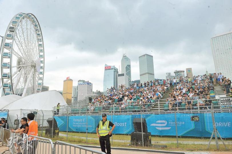 電動方程式賽車的門票上周五已售罄,但連日來場內看台鮮有滿座。昨日決賽期間,記者觀察龍和道、摩天輪底,和添馬公園看台座位只坐滿約八成,每逢賽車經過時觀眾均發出歡呼聲,雖然主持人多次提醒觀眾不要在看台上站立,但亦有不少人站到最前排觀賞賽事。(卓志恒攝)Formula E「重頭戲」電動方程式賽車決賽開始後,大批無買門票的巿民聚集在連接IFC的行人天橋,希望一睹賽車疾馳。由於觀賽巿民太多,現場保安設了封鎖線,防止巿民太靠近天橋邊。(馮凱鍵攝) 電動方程式賽車的門票上周五已售罄,但連日來場內看台鮮有滿座。昨日決賽期間,記者觀察龍和道、摩天輪底,和添馬公園看台座位只坐滿約八成,每逢賽車經過時觀眾均發出歡呼聲,雖然主持人多次提醒觀眾不要在看台上站立,但亦有不少人站到最前排觀賞賽事。(卓志恒攝)Formula E「重頭戲」電動方程式賽車決賽開始後,大批無買門票的巿民聚集在連接IFC的行人天橋,希望一睹賽車疾馳。由於觀賽巿民太多,現場保安設了封鎖線,防止巿民太靠近天橋邊。(馮凱鍵攝)