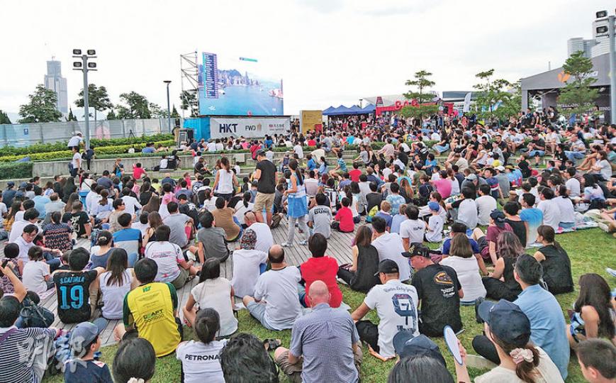 添馬公園eVillage昨午有至少數百市民圍坐草地,凝神觀看巨型屏幕直播賽事,雖然未能親見賽道,但仍然投入。(袁樂婷攝) 添馬公園eVillage昨午有至少數百市民圍坐草地,凝神觀看巨型屏幕直播賽事,雖然未能親見賽道,但仍然投入。(袁樂婷攝)