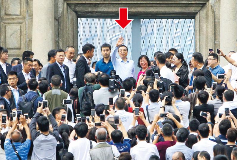 總理李克強遊覽大三巴前4小時,澳門警方已封鎖周邊地區,隨後又安排部分人進入大三巴歡迎李克強。圖中可見大部分進入封鎖線的人衣服上均貼上一個圓形貼紙(小圖)。(明報記者攝)
總理李克強遊覽大三巴前4小時,澳門警方已封鎖周邊地區,隨後又安排部分人進入大三巴歡迎李克強。圖中可見大部分進入封鎖線的人衣服上均貼上一個圓形貼紙(小圖)。(明報記者攝)