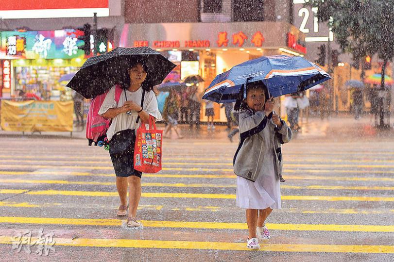 黑雨期間正值放學時間,全港各處都可見到家長及學生穿著雨衣撐傘冒雨狼狽回家。(馮凱鍵攝) 黑雨期間正值放學時間,全港各處都可見到家長及學生穿著雨衣撐傘冒雨狼狽回家。(馮凱鍵攝)