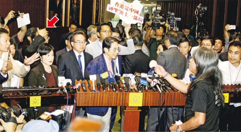 建制派議員昨集體離場後在議事廳外接受傳媒訪問,社民連梁國雄(前右)手持多片午餐肉打斷建制派發言,並把午餐肉拋向「咪兜」及擲落地下。及後民建聯陳恒鑌從地上拾起午餐肉拋向梁,梁拿肉塊反擊時掟中馬逢國頭部,馬即摸摸自己額頭(箭嘴示)。(郭慶輝攝)建制派議員離開傳媒區後,會議廳外地上遺下碎爛的午餐肉,需由清潔工清理。(楊柏賢攝) 建制派議員昨集體離場後在議事廳外接受傳媒訪問,社民連梁國雄(前右)手持多片午餐肉打斷建制派發言,並把午餐肉拋向「咪兜」及擲落地下。及後民建聯陳恒鑌從地上拾起午餐肉拋向梁,梁拿肉塊反擊時掟中馬逢國頭部,馬即摸摸自己額頭(箭嘴示)。(郭慶輝攝)建制派議員離開傳媒區後,會議廳外地上遺下碎爛的午餐肉,需由清潔工清理。(楊柏賢攝)