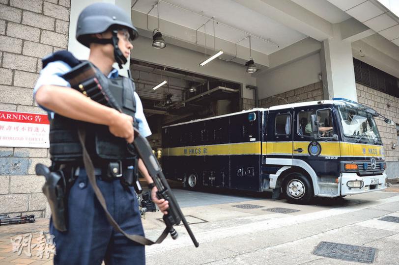 被告昨由囚車押解到高等法院受審，無論囚車進入或離開法庭，均有警員荷槍實彈護送，氣氛緊張。（蘇智鑫攝）