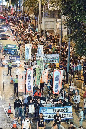 民陣昨晚舉行遊行反對釋法,由特首辦遊行至中辦聯,未能宣誓的兩名青政議員梁頌恆及游蕙禎,以及銅鑼灣書店店長林榮基都有參加。中聯辦外有數十名警員戒備,並架設多層鐵馬。民陣稱有1600人參與,警方則稱高峰期有750人。(楊柏賢攝) 民陣昨晚舉行遊行反對釋法,由特首辦遊行至中辦聯,未能宣誓的兩名青政議員梁頌恆及游蕙禎,以及銅鑼灣書店店長林榮基都有參加。中聯辦外有數十名警員戒備,並架設多層鐵馬。民陣稱有1600人參與,警方則稱高峰期有750人。(楊柏賢攝)