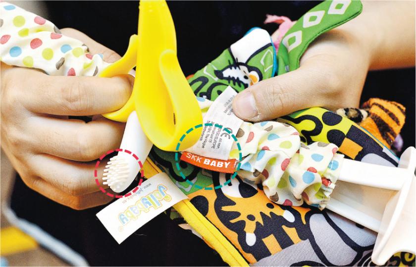 網店「YamazakiBaby山崎玩具」疑出售冒牌及不安全嬰兒用品,連女士於該店所購的牙刷形牙膠使用不足1年已有損壞(紅圈),恐女兒吞下膠粒,其他所購的物品應為品牌「Skip Hop」,但其後發現標籤卻顯示「skk baby」(綠圈)。(楊柏賢攝) 網店「YamazakiBaby山崎玩具」疑出售冒牌及不安全嬰兒用品,連女士於該店所購的牙刷形牙膠使用不足1年已有損壞(紅圈),恐女兒吞下膠粒,其他所購的物品應為品牌「Skip Hop」,但其後發現標籤卻顯示「skk baby」(綠圈)。(楊柏賢攝)
