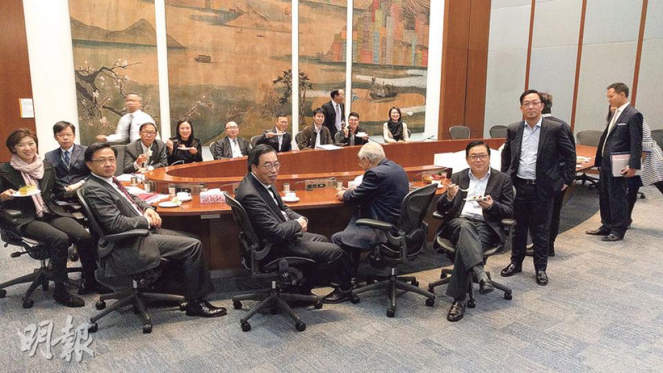 大會主席梁君彥(前左三)同一眾建制派議員應記者要求,食住餅擺甫士,個個都笑容滿面,睇嚟食得津津有味。(梁智康攝) 大會主席梁君彥(前左三)同一眾建制派議員應記者要求,食住餅擺甫士,個個都笑容滿面,睇嚟食得津津有味。(梁智康攝)