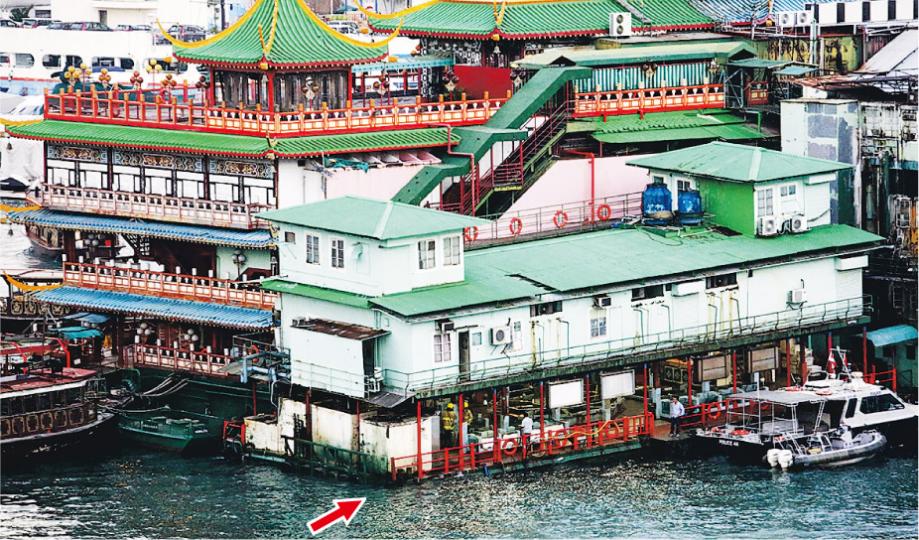 珍寶海鮮舫相連的養魚躉船入水傾側下沉(箭嘴示)。消防員利用水泵將船的積水排走,以防止繼續下沉。(伍浦鋒攝) 珍寶海鮮舫相連的養魚躉船入水傾側下沉(箭嘴示)。消防員利用水泵將船的積水排走,以防止繼續下沉。(伍浦鋒攝)
